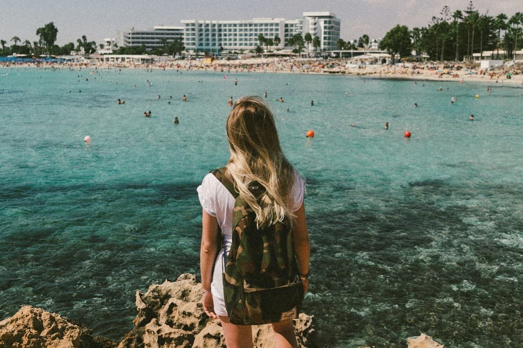 Traveller looking out over a turquoise bay